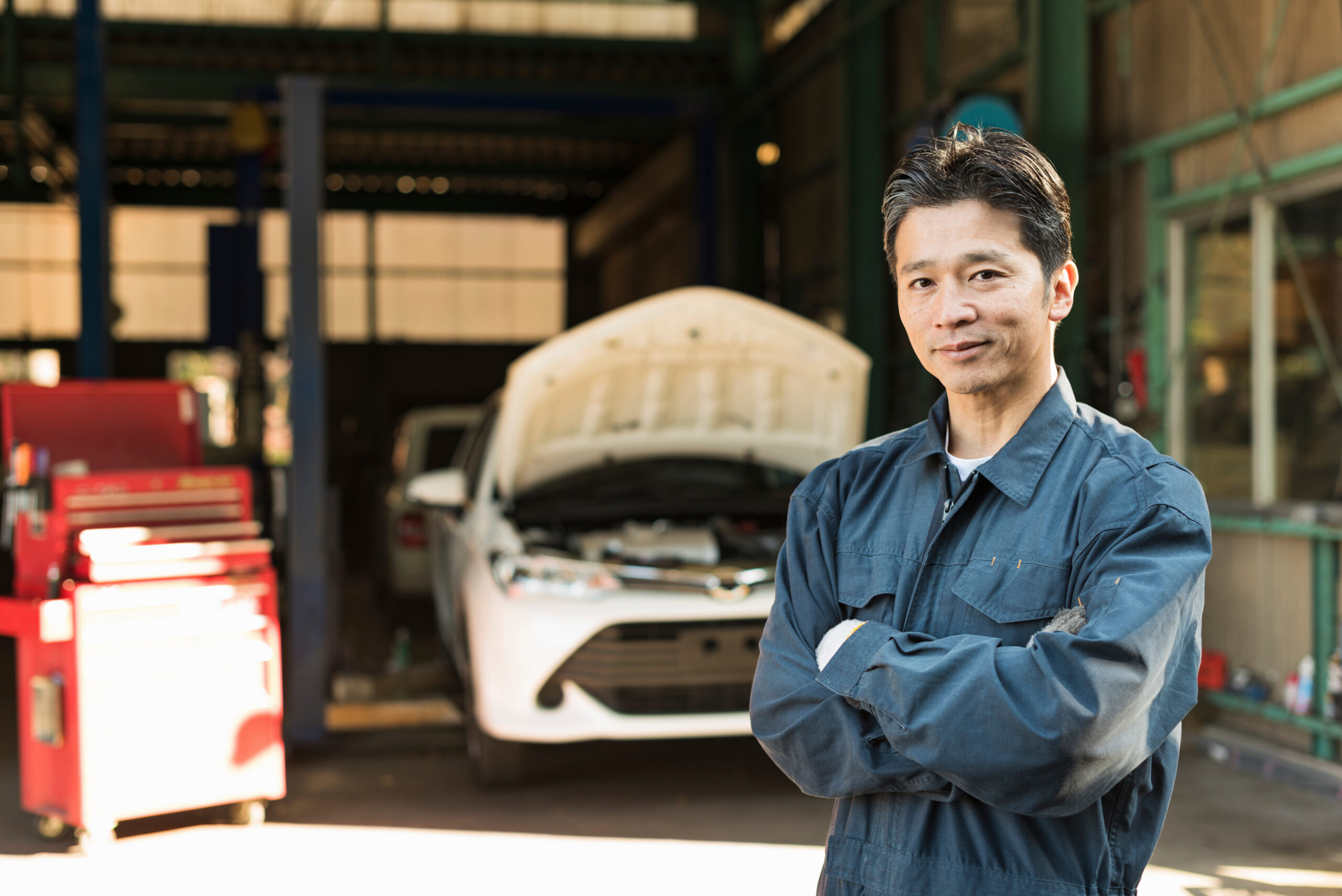 自動車整備士が工場前に立つ様子